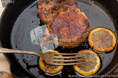 Image of pork chop seared on iron skillet