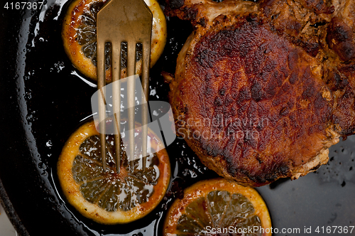 Image of pork chop seared on iron skillet