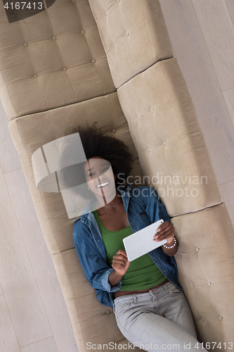 Image of african american woman at home with digital tablet top view