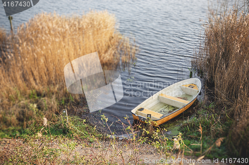 Image of Yellow fishing boat in a dark lake