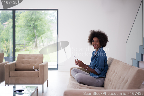 Image of african american woman at home with digital tablet