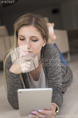 Image of young women used tablet computer on the floor