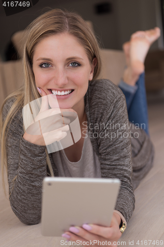 Image of young women used tablet computer on the floor