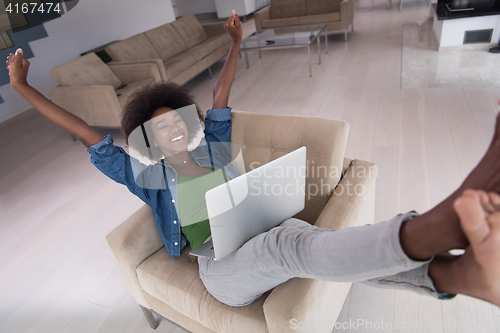 Image of African American women at home in the chair using a laptop