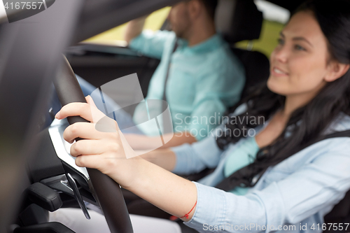 Image of happy man and woman driving in car