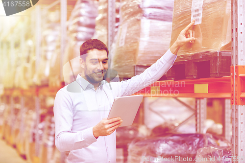 Image of happy businessman with tablet pc at warehouse