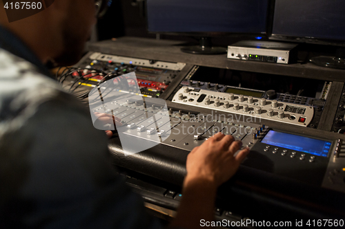 Image of man using mixing console in music recording studio