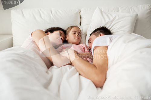 Image of happy family sleeping in bed at home