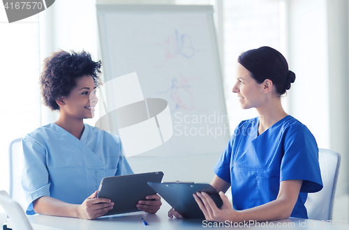 Image of happy doctors with tablet pc meeting at hospital