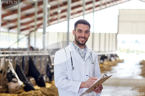 Image of veterinarian with cows in cowshed on dairy farm