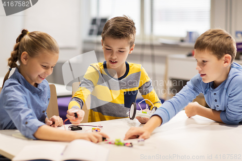 Image of happy children building robots at robotics school