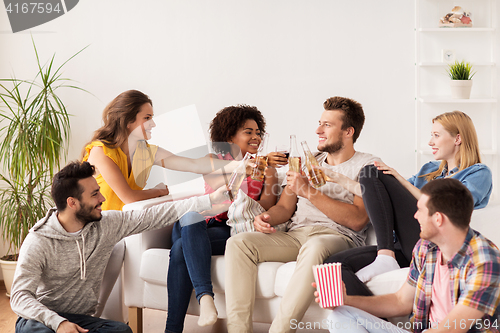 Image of happy friends with popcorn and beer at home