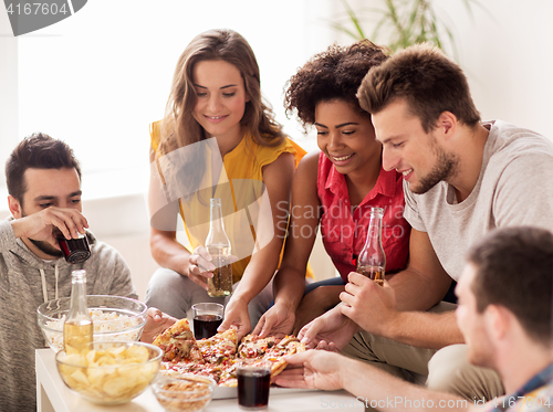 Image of happy friends with drinks eating pizza at home