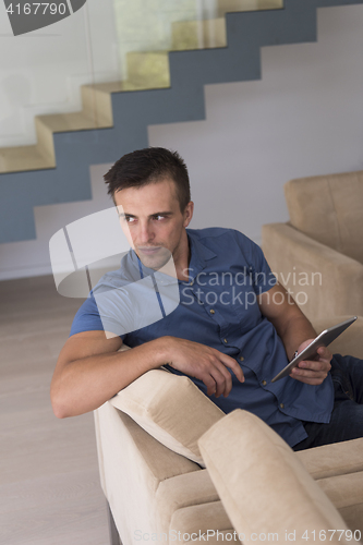 Image of young man using a tablet at home