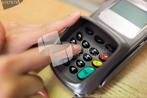 Image of close up of hand entering code to money terminal