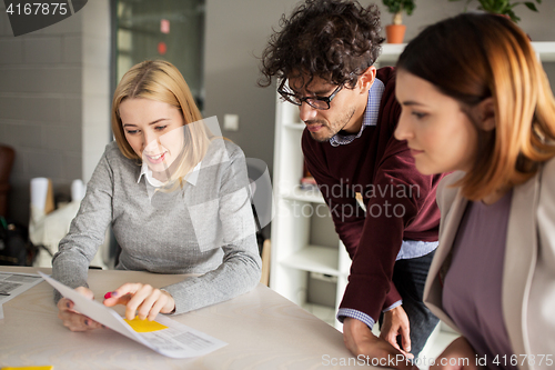 Image of happy business team with papers in office