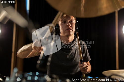 Image of male musician playing drums and cymbals at concert