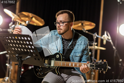 Image of man playing guitar at studio rehearsal