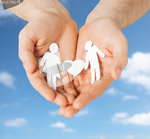 Image of hands with paper couple pictogram and heart shape