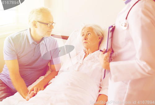 Image of senior woman and doctor with clipboard at hospital