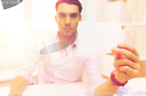 Image of close up of businessman with blank paper at office