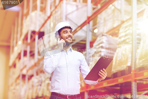 Image of man with clipboard and smartphone at warehouse