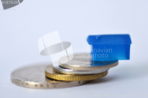 Image of Little plastic house on metal coins