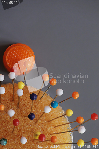 Image of  orange thimble Pillow and multicolored pins
