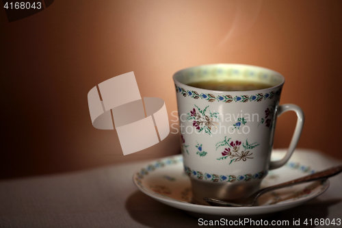 Image of  cup with hot tea and steam on background