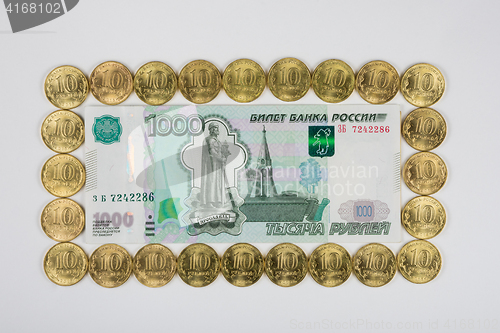 Image of Russian thousandth banknote is imposed on a ten coins perimeter