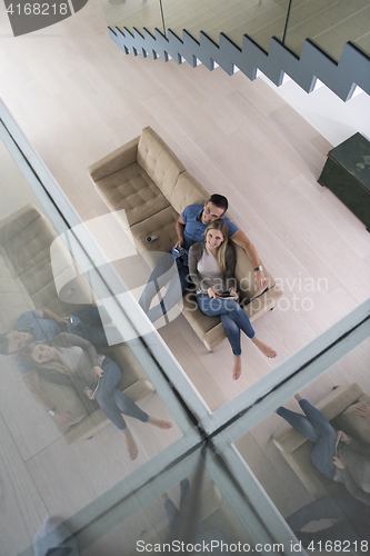 Image of youg couple in living room with tablet top view