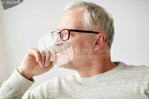 Image of close up of senior man in glasses thinking