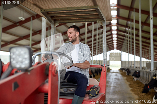 Image of man or farmer driving tractor at farm