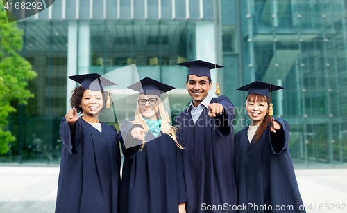 Image of happy students or bachelors pointing finger at you