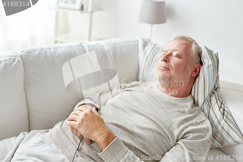 Image of senior man sleeping on sofa at home