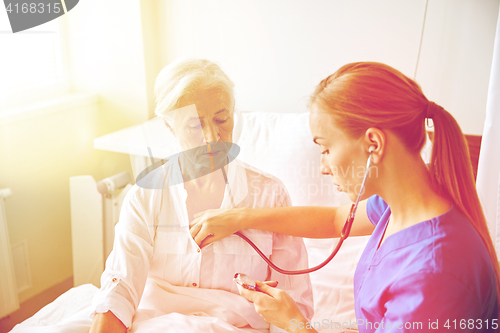 Image of nurse with stethoscope and senior woman at clinic