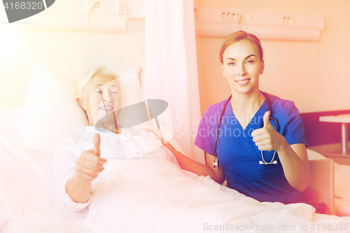 Image of nurse and senior woman showing thumbs up at clinic