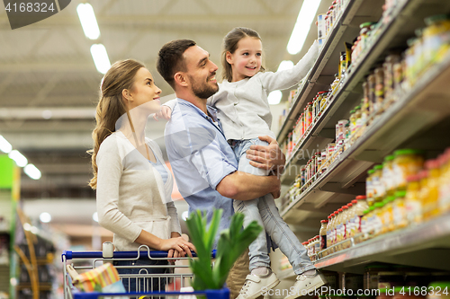 Image of family with food in shopping cart at grocery store