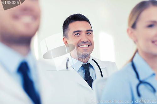 Image of happy doctor over group of medics at hospital