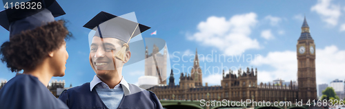 Image of happy students or bachelors in mortar boards