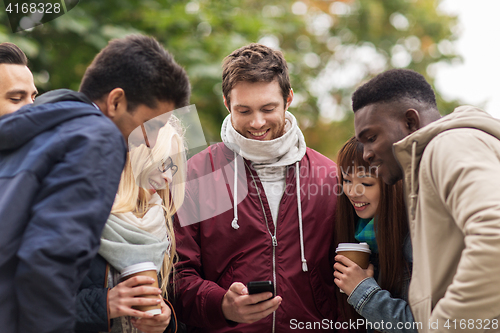 Image of happy friends with smartphone and coffee outdoors