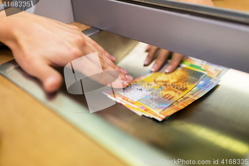 Image of clerk giving cash money to customer at bank office