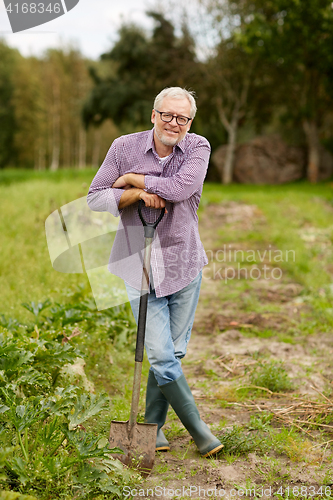 Image of happy senior man with shovel at garden or farm