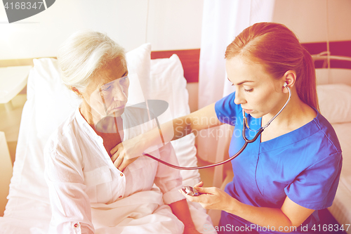 Image of nurse with stethoscope and senior woman at clinic