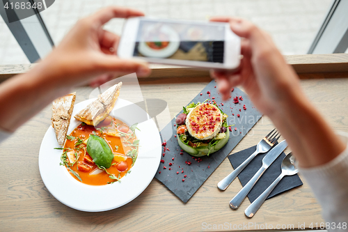 Image of hands with smartphone photographing food