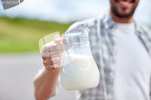 Image of man or farmer with jug of milk at countryside
