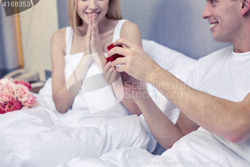 Image of close up of man giving woman engagement ring