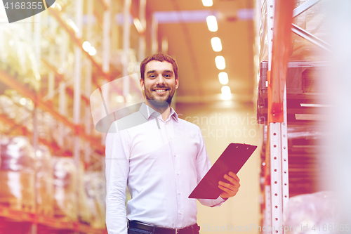 Image of happy businessman with clipboard at warehouse