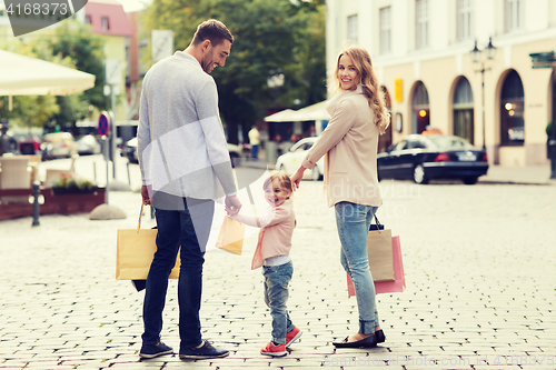 Image of happy family with child and shopping bags in city