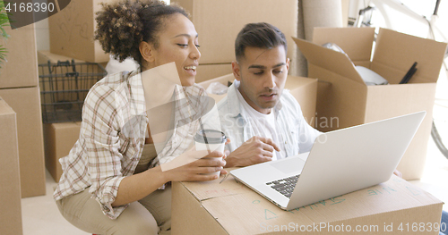 Image of Young mixed race couple using laptop